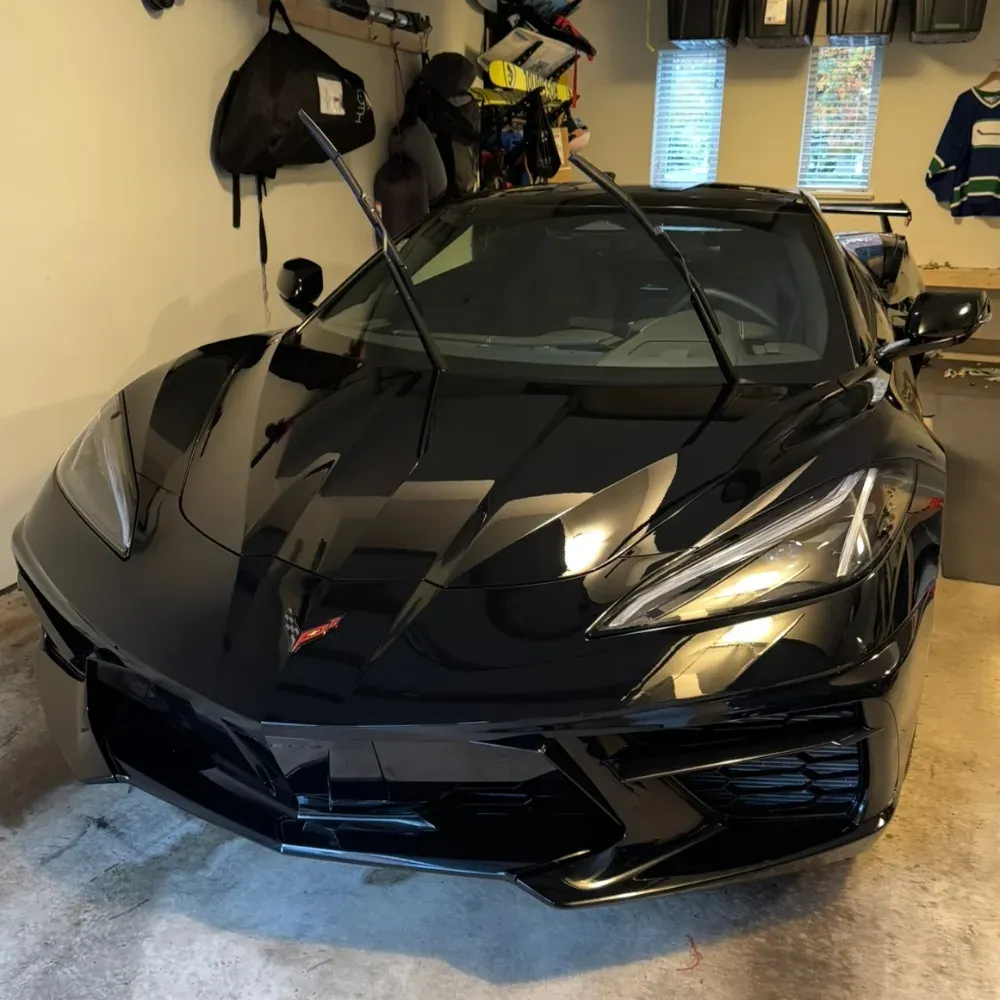 Black Corvette C8 in a garage with the wiper arms raised after washing