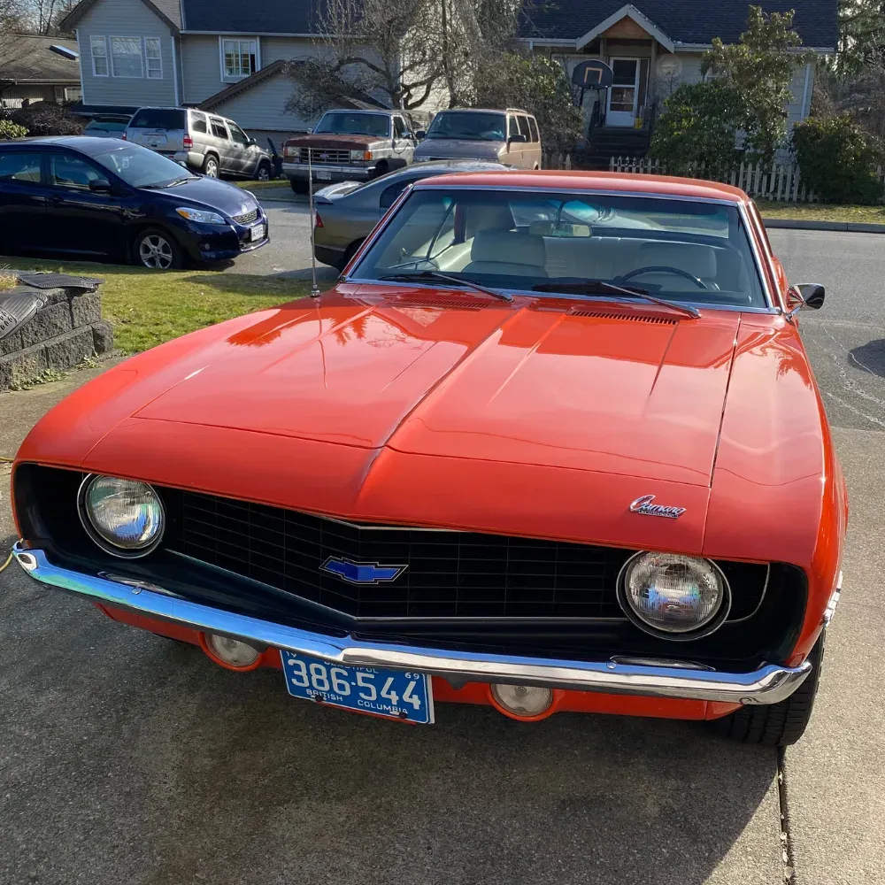 Orange 1969 Chevrolet Camaro in a driveway after an exterior detail