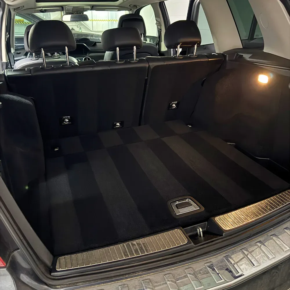 Spotless black carpet in an SUV cargo area after an interior detail