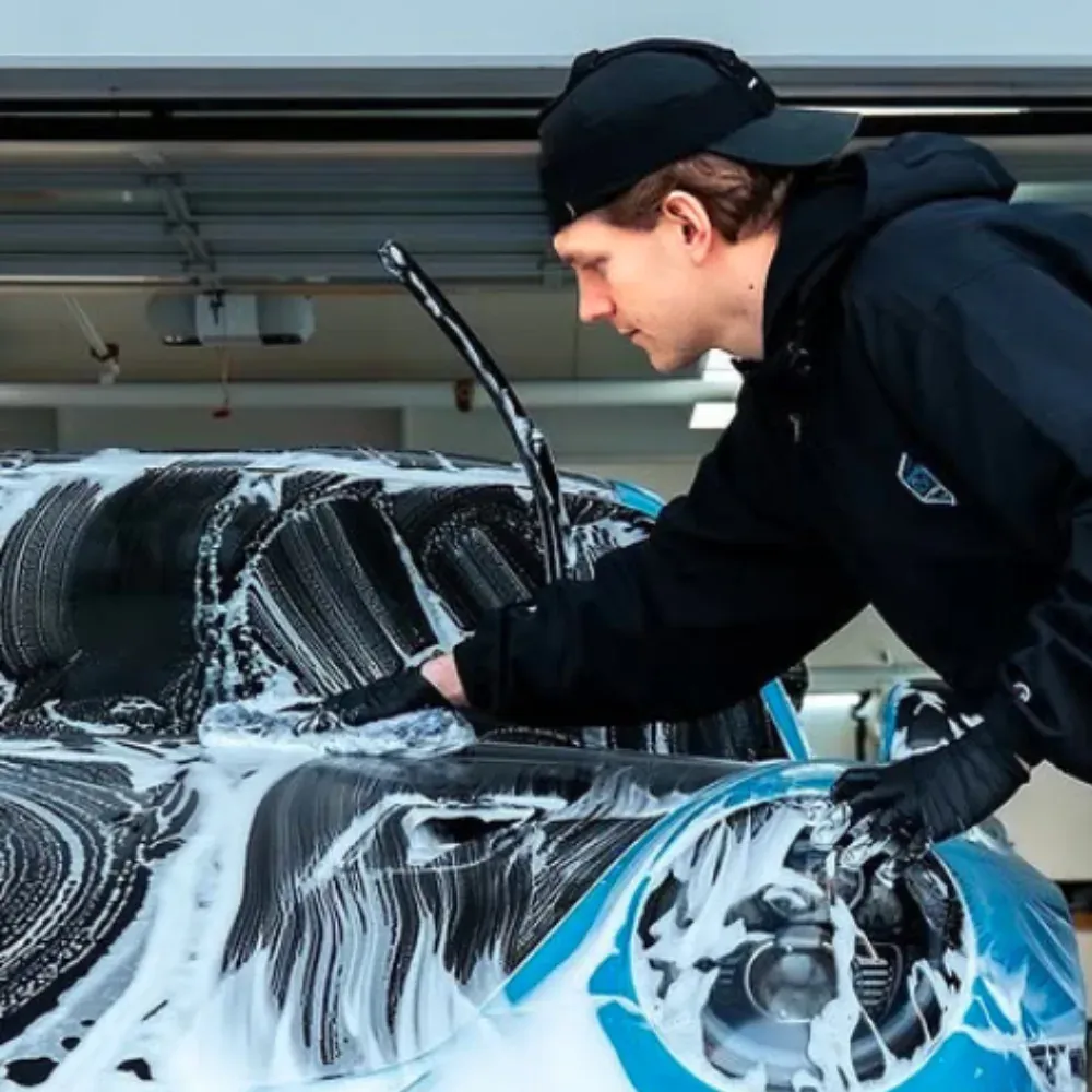 Lucas, owner of North Van Detailing, hand washing a foam-covered Porsche 911 GT3 RS
