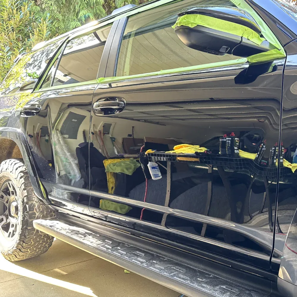 Deep gloss on the black side panels of the same Toyota 4Runner after a two-step polish