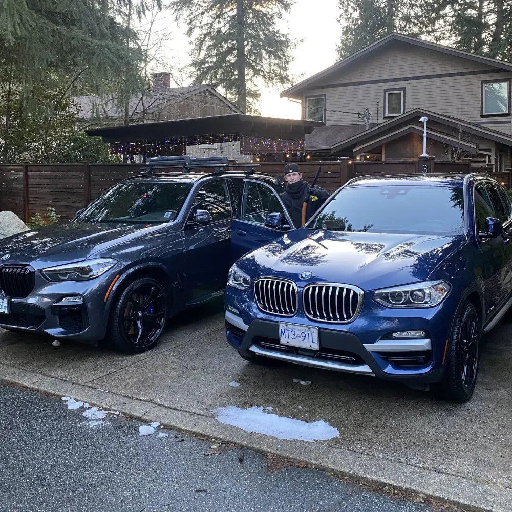 Two BMW SUVs parked side by side in a North Shore driveway after being detailed